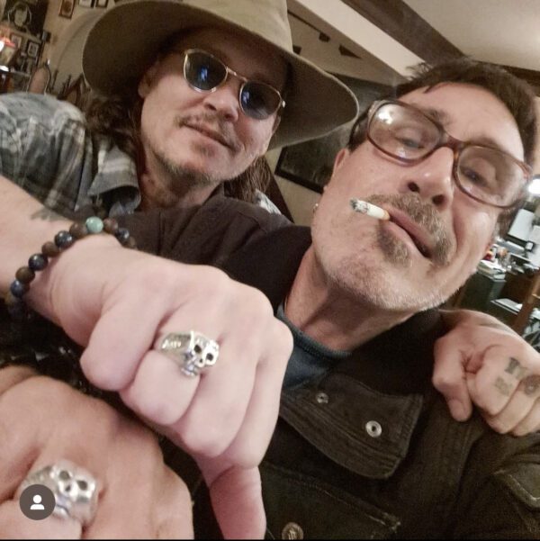 Two men showing rings, one wearing a hat and sunglasses.