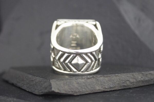Intricately designed silver ring with geometric patterns.