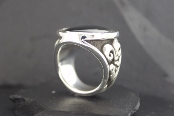 A detailed silver ring with intricate floral engravings.