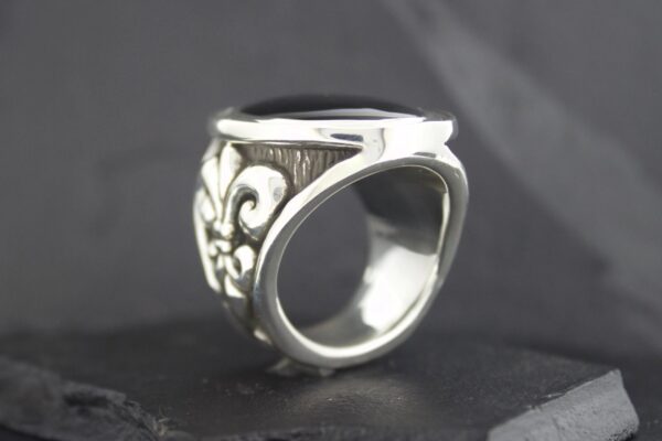 Close-up of a silver ring with intricate floral engravings.