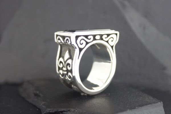 Intricately designed silver ring with ornate patterns.