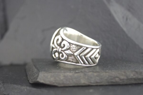 Silver ring with intricate geometric and floral designs.