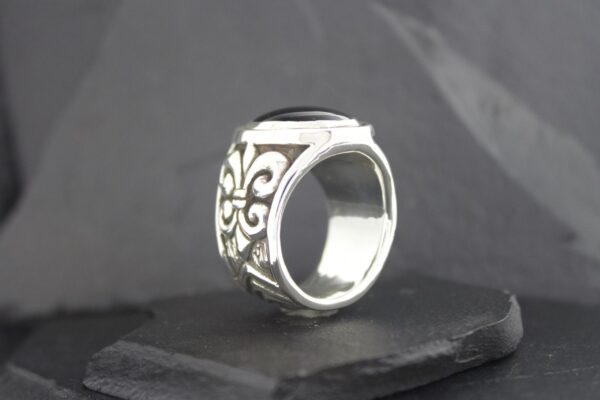 A silver ring with intricate floral engravings.
