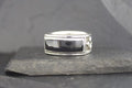 Silver ring with a rectangular black stone set in the center.