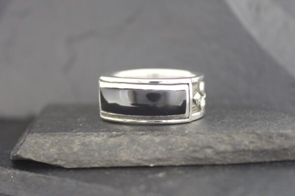 Silver ring with a rectangular black stone set in the center.