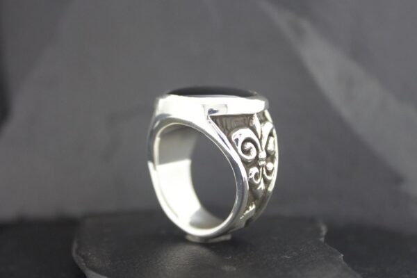Intricately designed silver ring with ornate patterns.