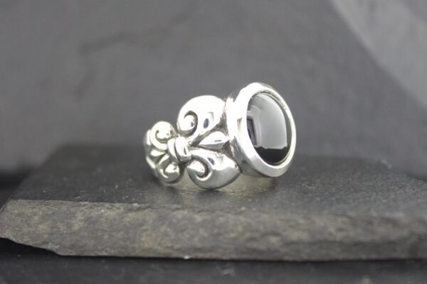 Elegant silver ring with black stone and intricate design.