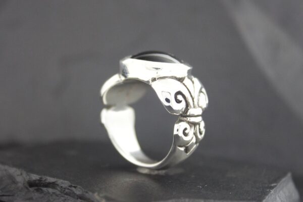 Elegant silver ring with intricate swirled designs.