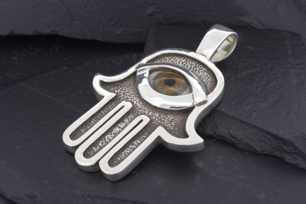 Silver Hamsa hand pendant with an eye in the center.
