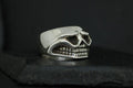 Silver skull-shaped ring with detailed teeth and goggles design.
