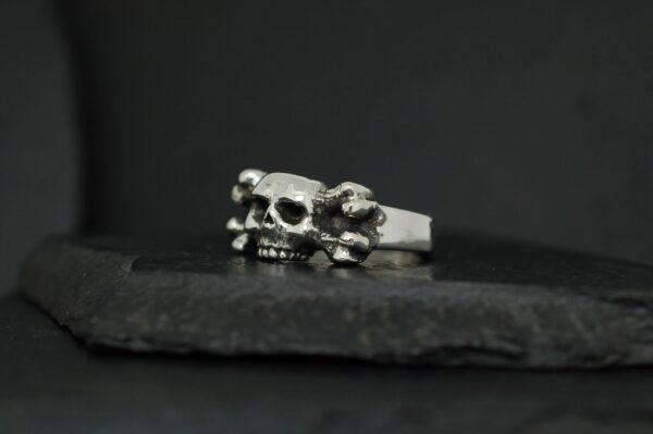 A silver ring featuring a detailed skull design.