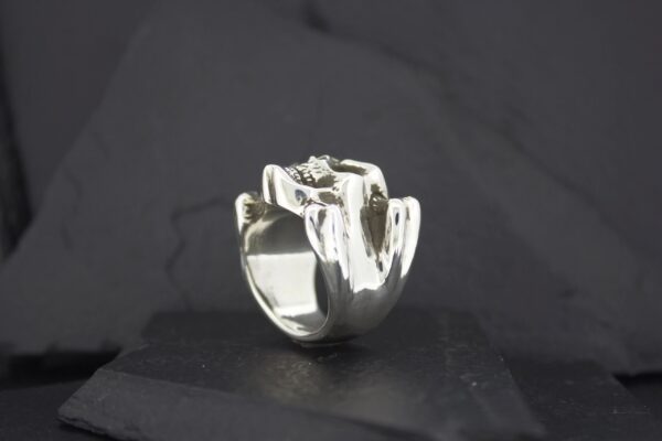 A silver ring shaped like a hand making a gesture.