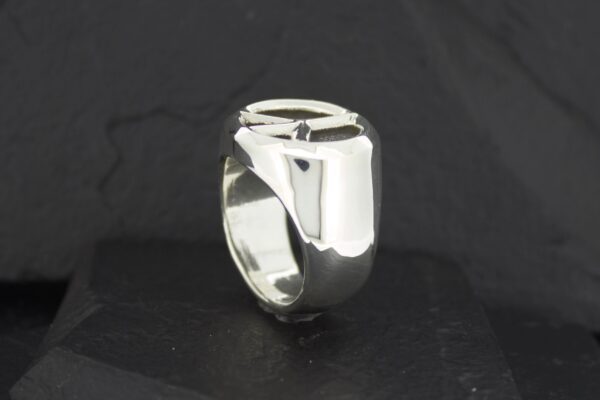 Shiny silver ring with a smooth, modern design on a black background.