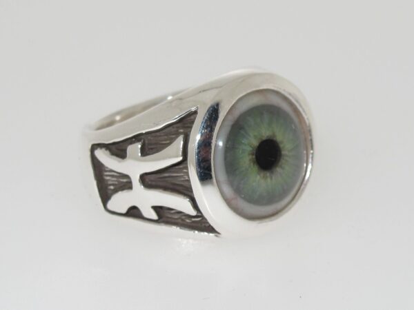 Silver ring with a realistic green eye design and black accents.