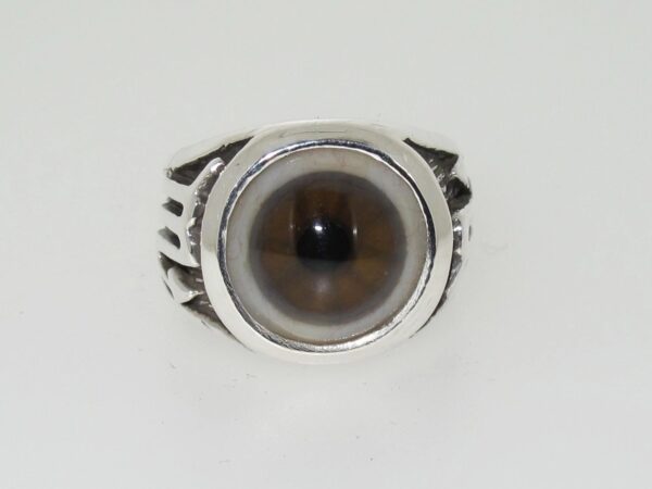 Silver ring with a round, brownish gemstone.