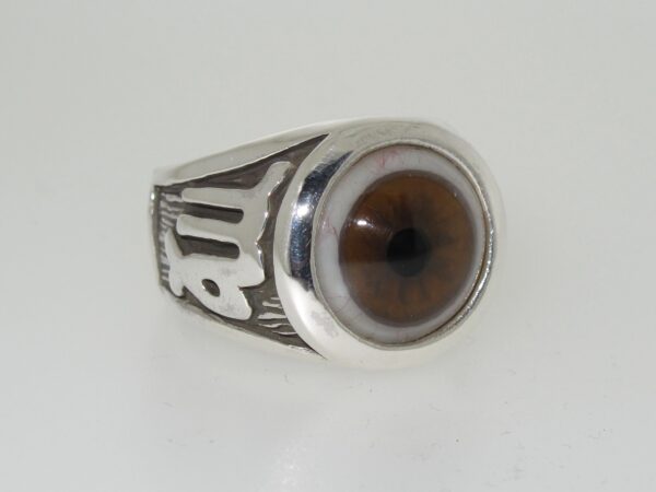 A silver ring with a realistic brown eye design.