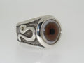 A silver ring featuring a realistic eye design with a snake detail on the band.
