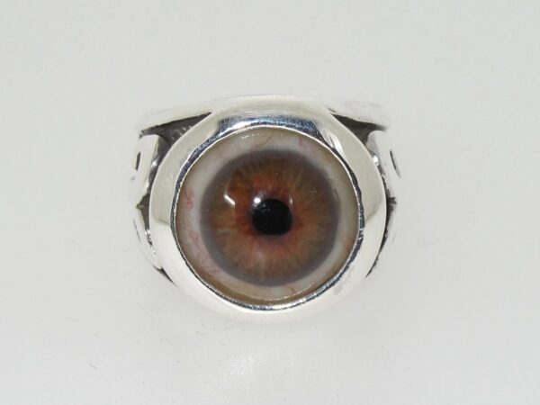 A silver ring with a realistic brown eye design.