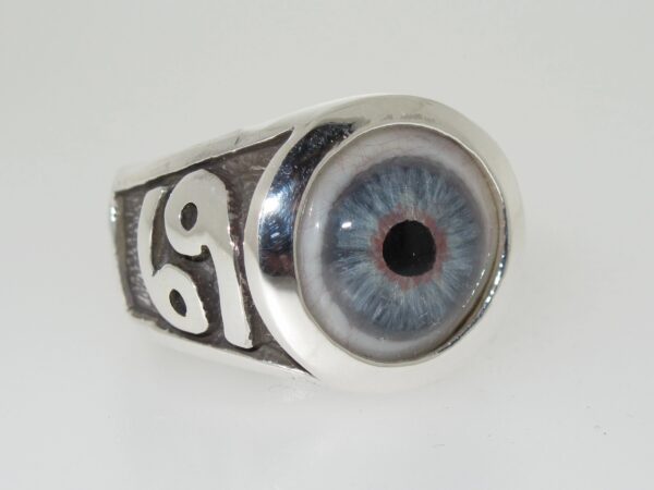 A silver ring with a detailed blue eye design and the number 69 on the side.