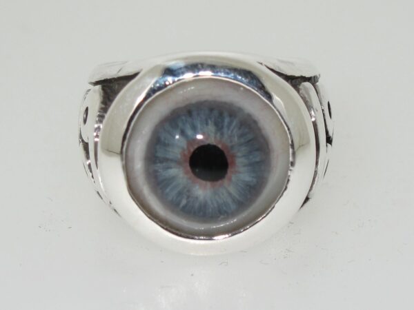 A silver ring featuring a realistic blue eye design.