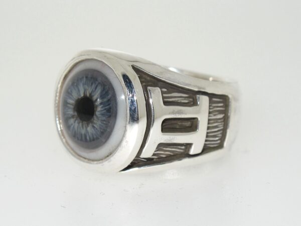 A silver ring featuring a realistic human eye design.