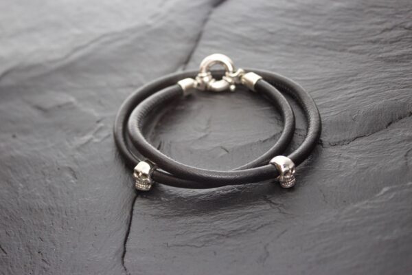 Elegant black double-strand bracelet with silver accents on dark slate.