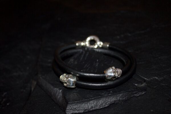 Elegant black bracelet with silver and crystal accents on a dark surface.
