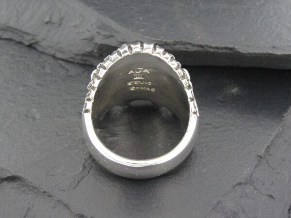 Close-up of a silver ring with engraved text inside.