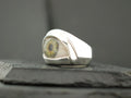 A silver ring featuring a realistic eye design.