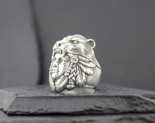 Silver ring featuring a bear and Native American chief design.