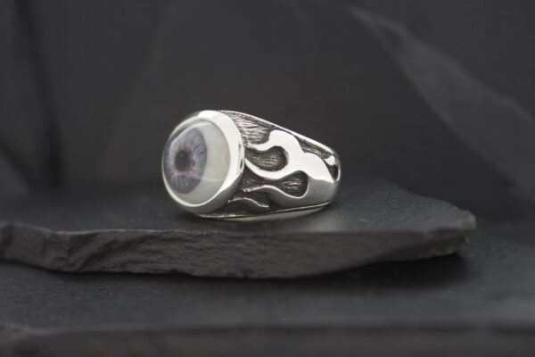 Silver ring with black flame design and round center stone.