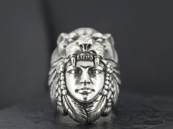 A silver ring featuring a detailed face with a lion headdress.
