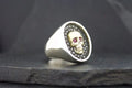 Silver ring with a skull design and red eyes.
