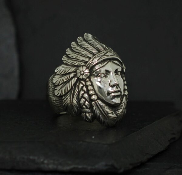 Metal sculpture of a Native American chief's head with a feathered headdress.