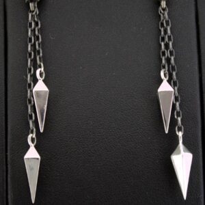 Pair of silver pendulum earrings with chain links on black background.