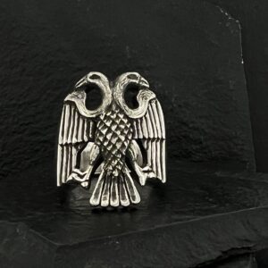 Silver double-headed eagle emblem on black fabric.