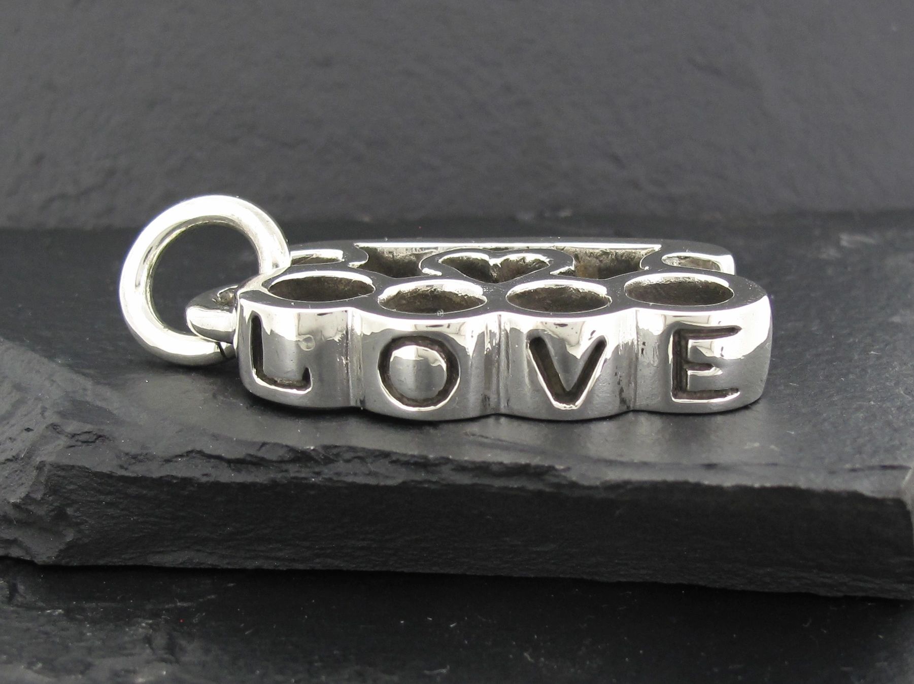 Silver charm with the word LOVE spelled out on four blocks.