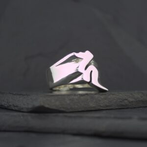 A silver ring featuring a stylized, abstract human figure design.