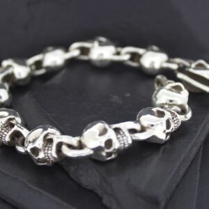 Silver skull and bone bracelet on black fabric.