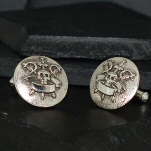 Vintage silver cufflinks with a detailed heraldic crest design.