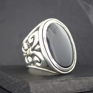 Elegant silver ring with a large black oval stone and intricate floral details.