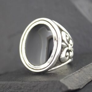 Silver ring with ornate floral design and empty oval bezel.