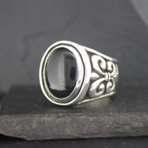 Elegant silver ring with a polished black stone and intricate side designs.