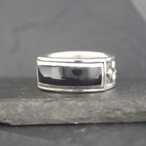 Silver ring with a rectangular black stone set in the center.
