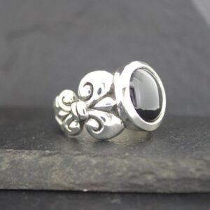 Elegant silver ring with black stone and intricate design.