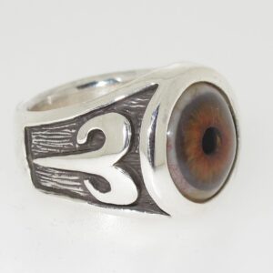 Silver ring with an eye design and ornate side patterns.