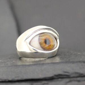 A unique silver ring featuring a realistic amber-colored eye design.